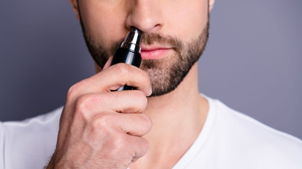 A man uses a nose hair trimmer 