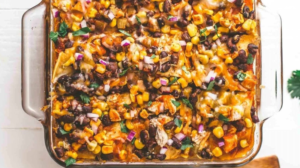 A glass casserole dish full of chicken enchilada casserole. 