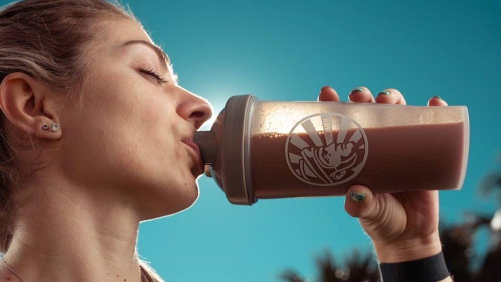 A woman drinking a protein shake.