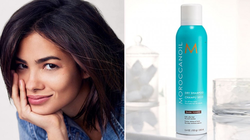 A woman with dark hair; a blue bottle of dry shampoo