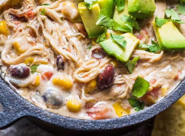 White chicken chili topped with fresh sliced avocado.