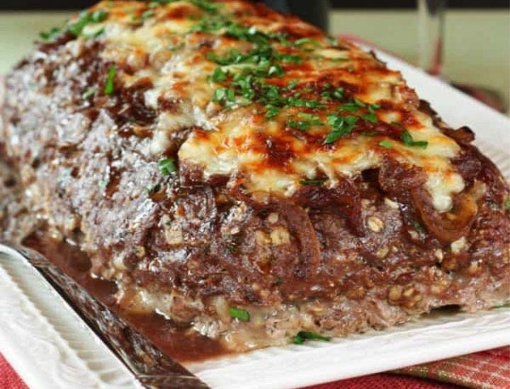 French Onion Meatloaf served on a white rectangular serving dish.