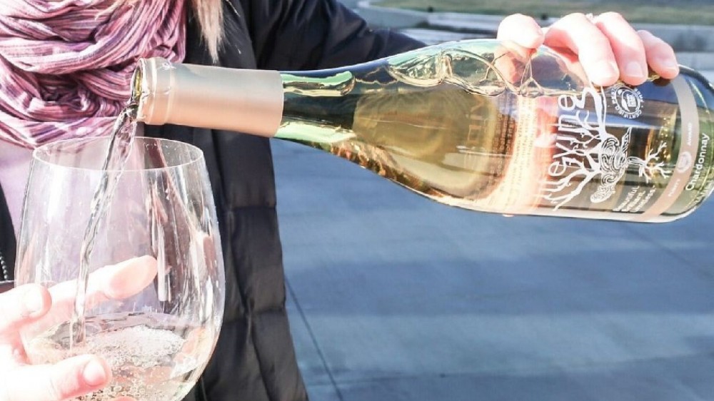 A woman pouring a glass of low-carb Lifevine chardonnay in a glass without worrying about hurting her diet.