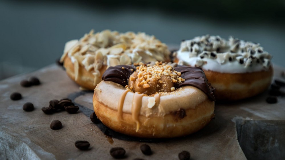 Three doughnuts on a table.