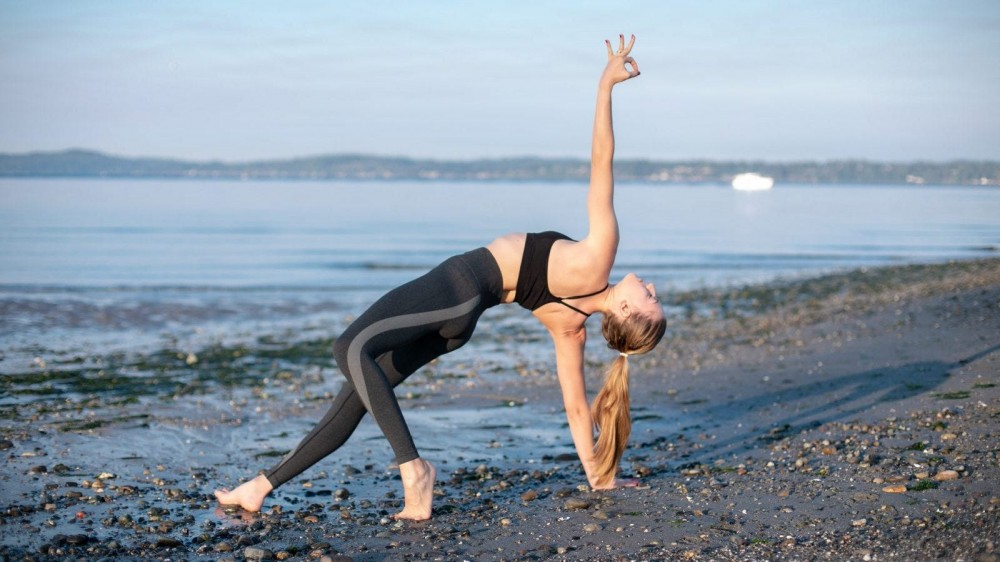 Woman doing yoga on the beach.