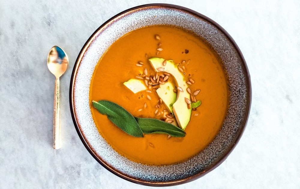 Creamy pumpkin soup on a marble tabletop.