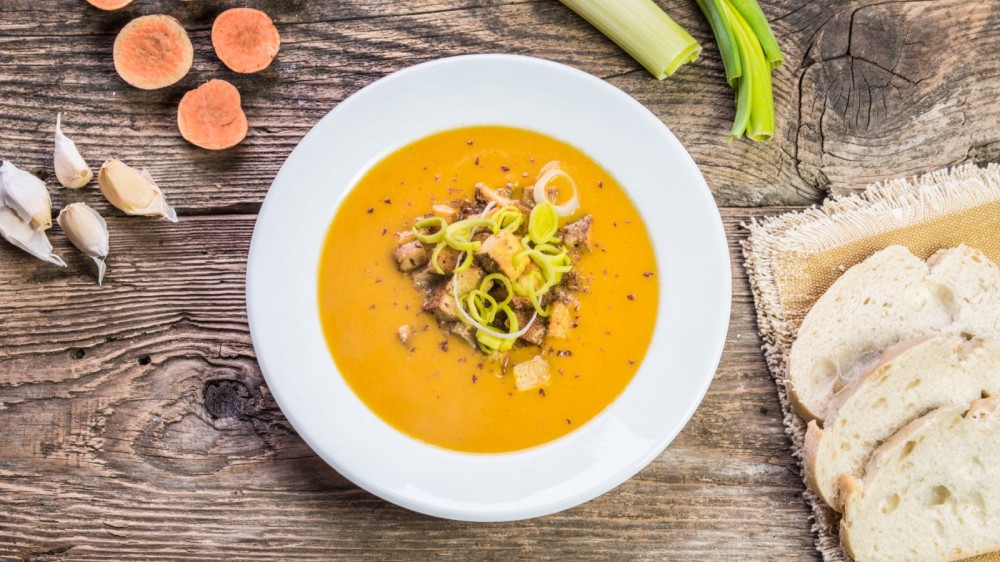 Leek and sweet potato soup on a wooden table.