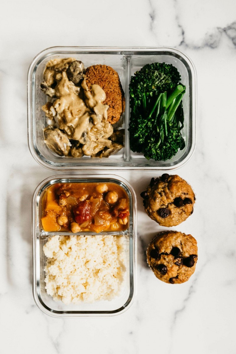 A few glasslock, divided storage containers hold various beans, grains, and vegetables.