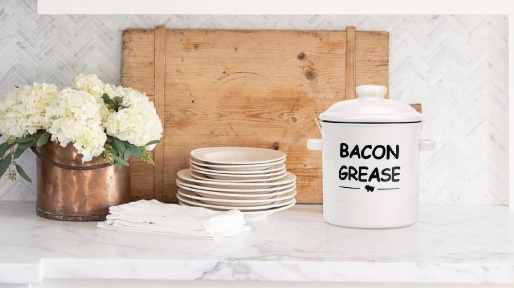 A ceramic container of bacon grease placed over a countertop.