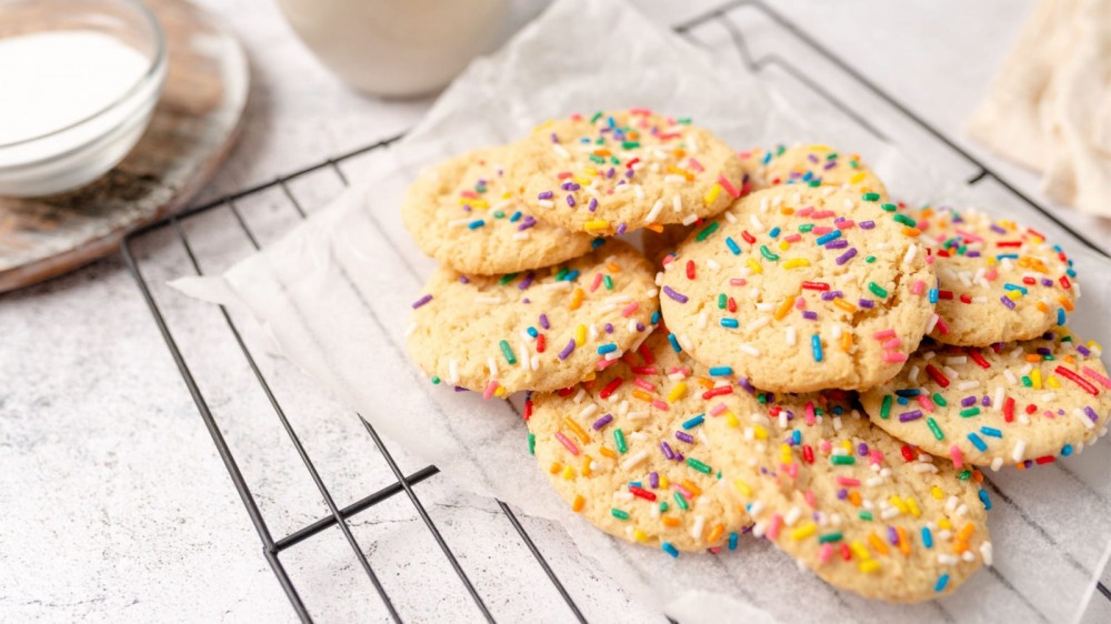 A small pile of sugar cookies with sprinkles. 