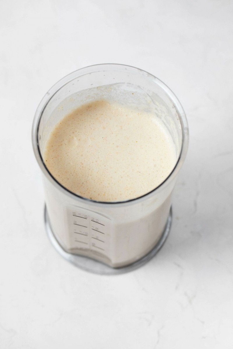 A creamy mixture is pictured in a personal blender.